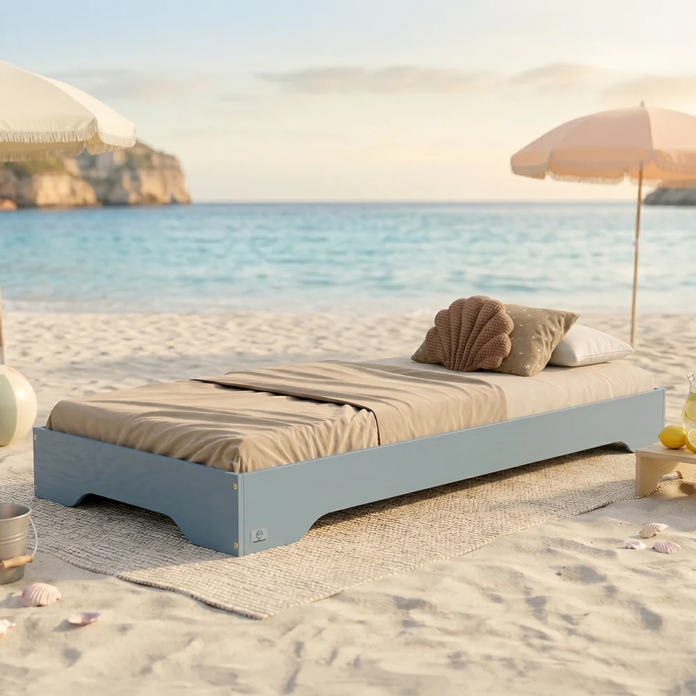 Ein Foto, das das Bett TILA 7 in der Farbe blau am Strand zeigt
